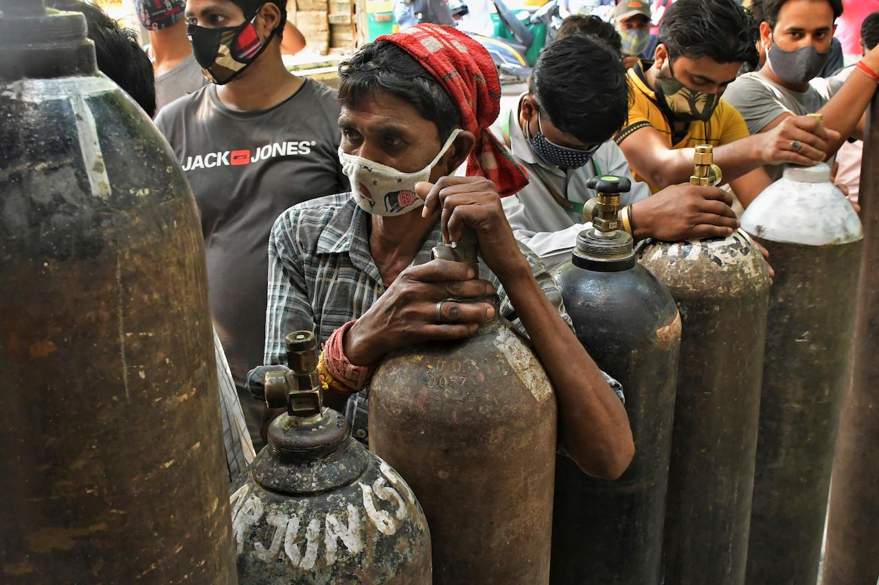 Indians wait to refill oxygen cylinders for Covid-19 patients at a gas supplier facility in New Delhi, India, May 8. Infections have swelled in India since February in a disastrous turn blamed on more contagious variants as well as government decisions to allow massive crowds to gather for religious festivals and political rallies. Photo: AP