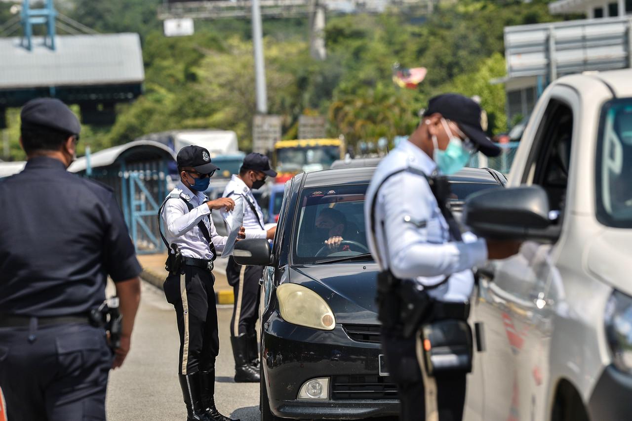 Police check the permits of drivers at a roadblock at the Gombak toll plaza along the East Coast Highway, as the movement control order in Kuala Lumpur enters its third day. Photo: Bernama