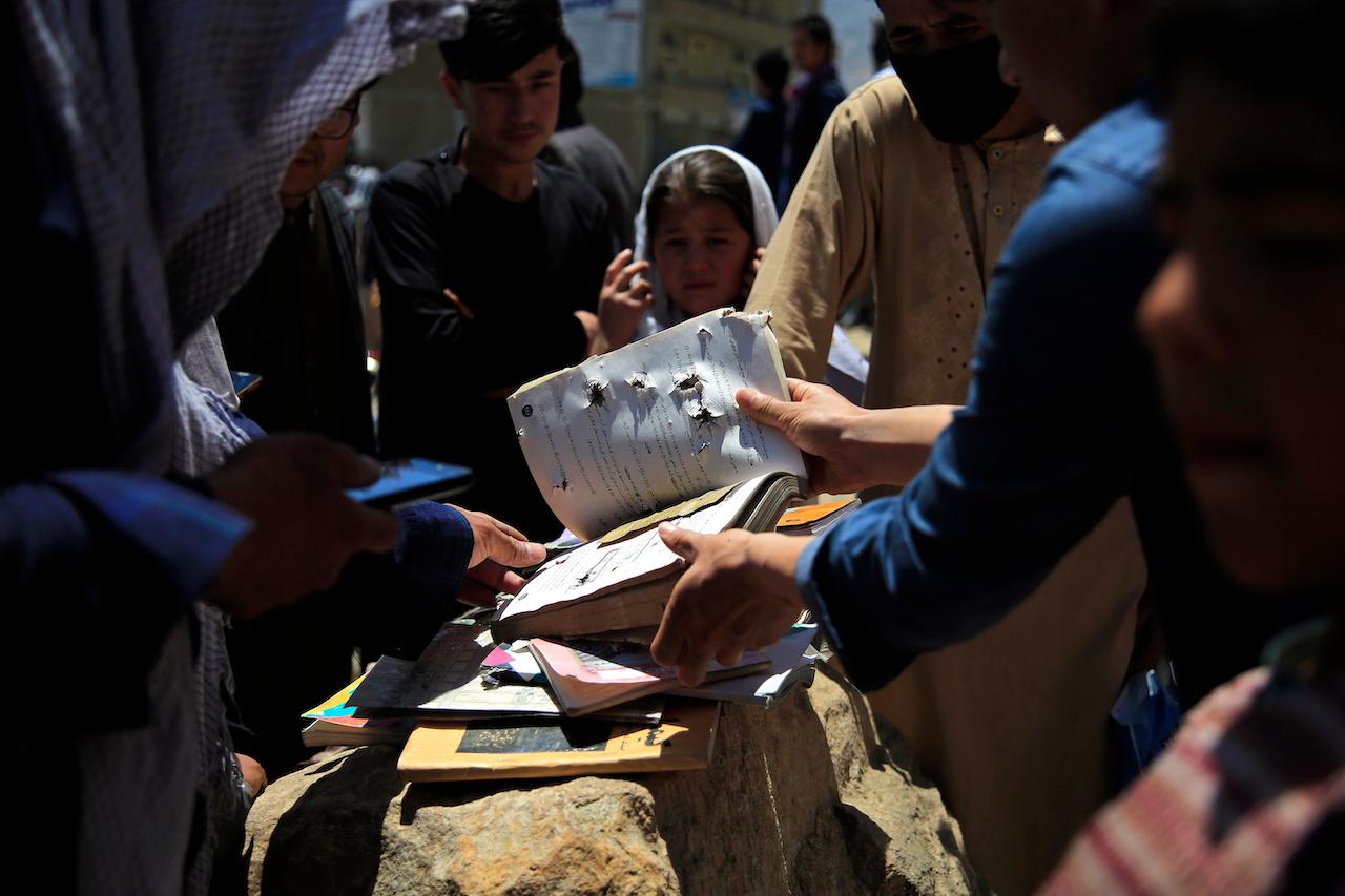 Afghans go through belongings left behind after deadly bombings on Saturday near a school in Kabul, Afghanistan, May 9. Photo: AP