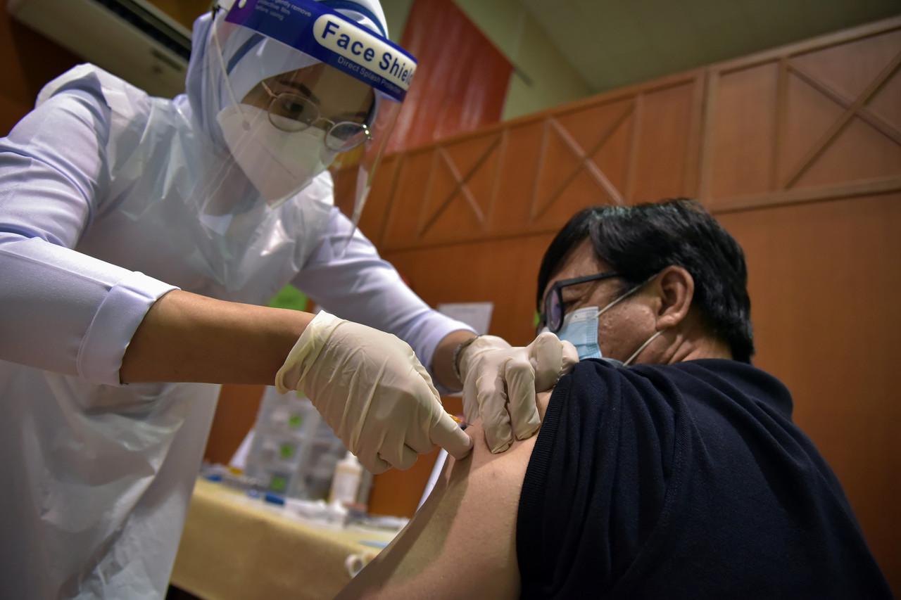 A health worker administers a shot of Covid-19 vaccine at a vaccination centre in Labuan. Photo: Bernama