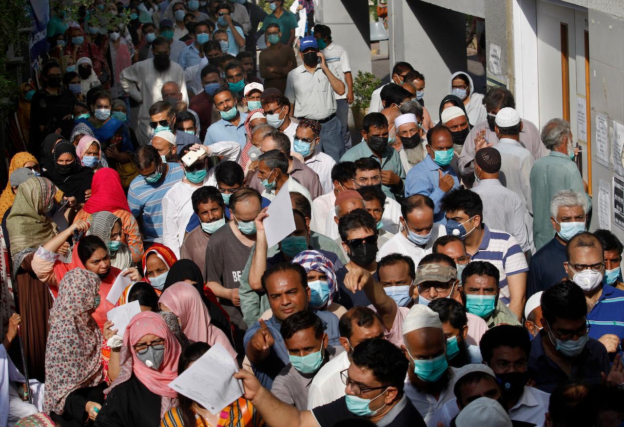 People stand in queues while they wait for their turn to receive the first shot of the Sinopharm Covid-19 vaccine at a vaccination centre in Karachi, Pakistan, May 8. Photo: AP