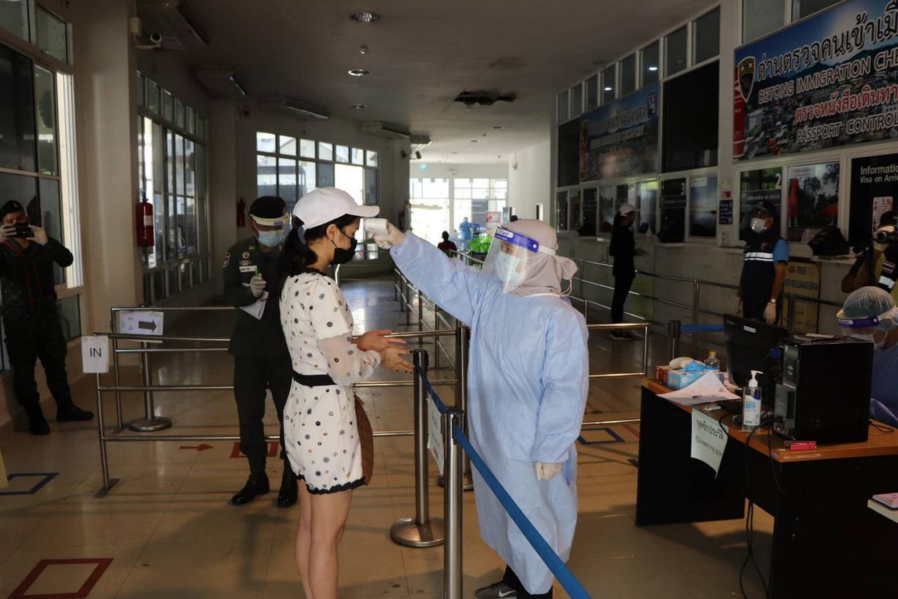 Petugas kesihatan mengambil bacaan suhu badan warga Thai yang pulang dari Malaysia di pintu sempadan Betong, Yala bagi mengekang penularan Covid-19. Gambar: Bernama