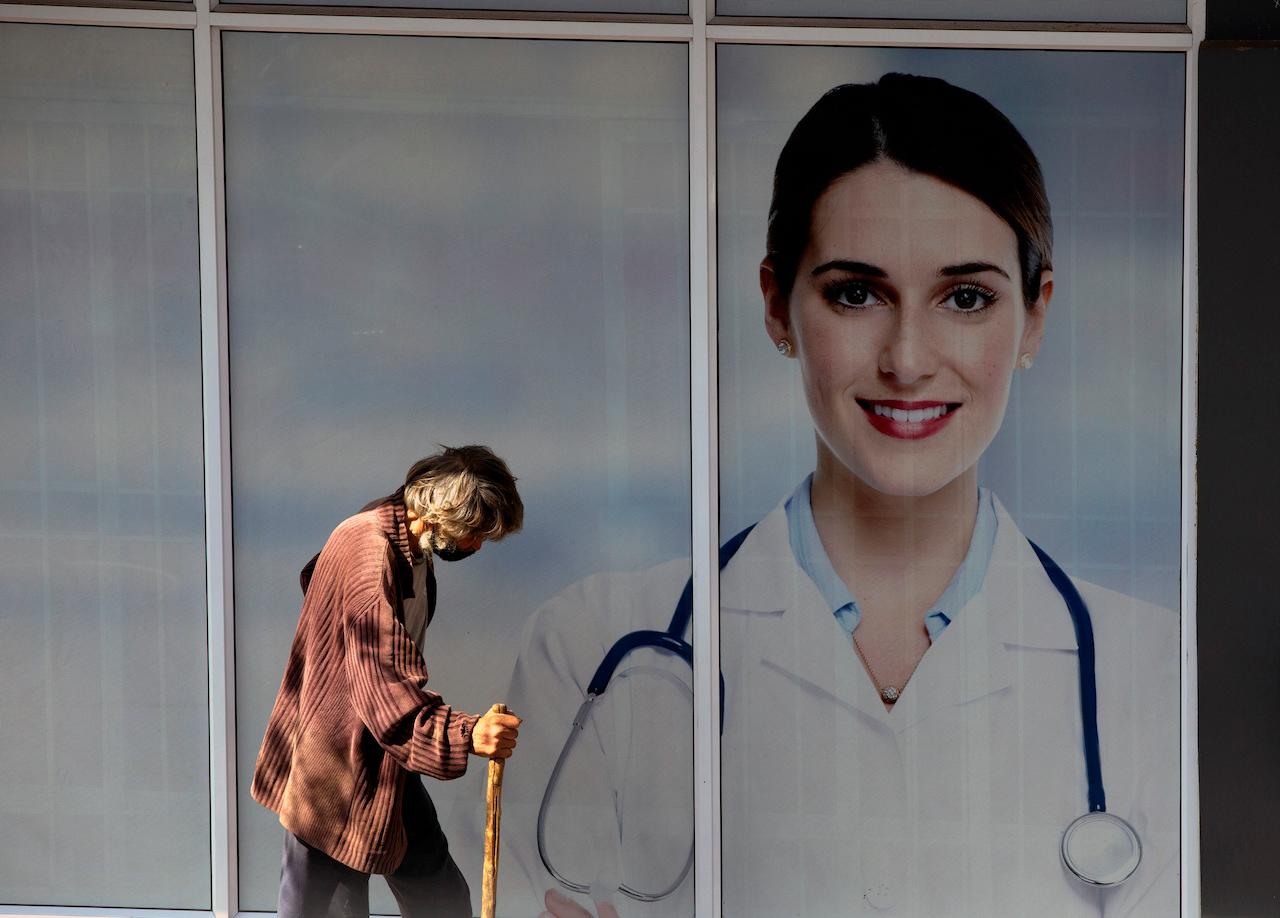 A man passes doctors consulting rooms in Johannesburg, April 16. Sub-Saharan Africa has administered the fewest vaccines relative to its population of any region, with roughly just eight doses per 1,000 people. Photo: AP