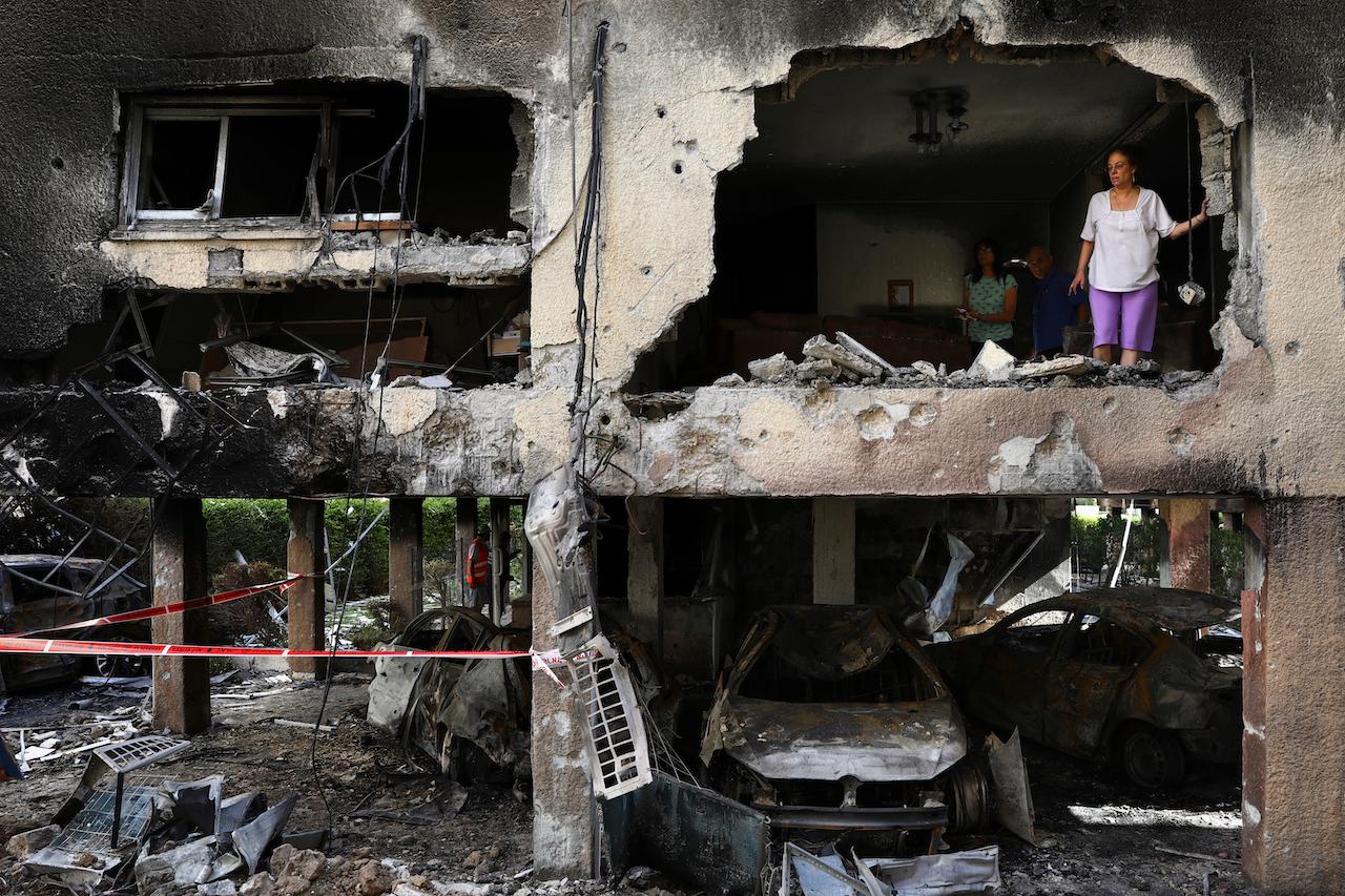 A family inspects the damage to their apartment after it was hit by a rocket fired from the Gaza Strip over night in Petah Tikva, central Israel, May 13. Photo: AP