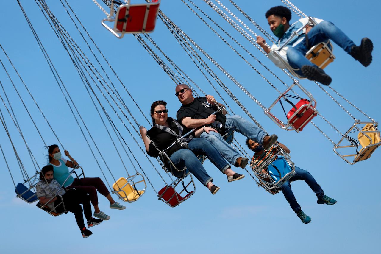 People enjoy themselves on a wave swinger ride at Chicago's Navy Pier, May 14. The US Centers for Disease Control and Prevention has eased its guidelines, saying fully vaccinated people can resume activities without wearing masks. Photo: AP
