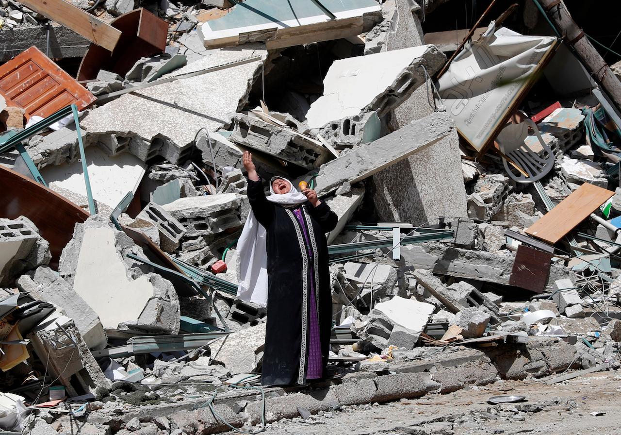 A woman reacts while standing near the rubble of a building that was destroyed by an Israeli airstrike on Saturday that housed the AP, broadcaster Al-Jazeera and other media outlets, in Gaza City, May 16. Photo: AP