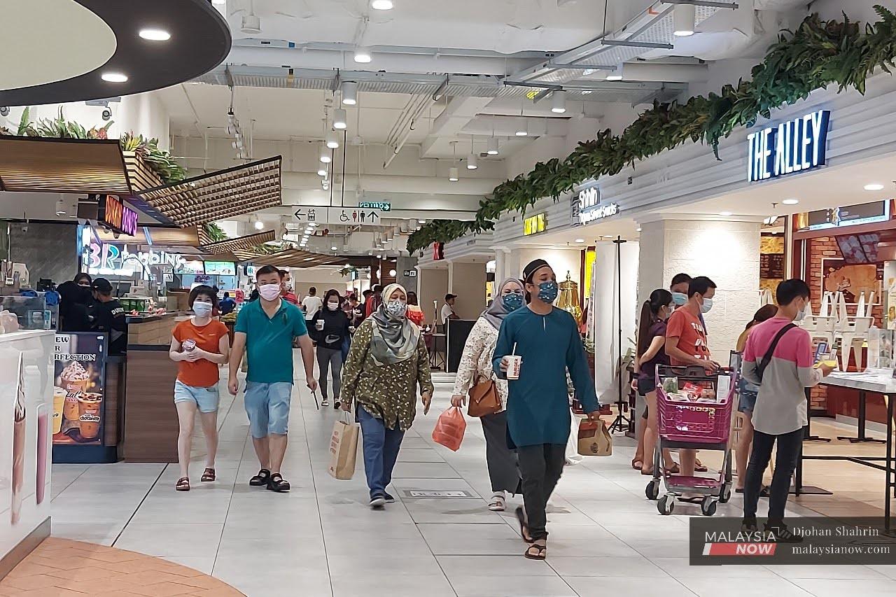 Shoppers walk through a mall in Kuala Lumpur over the Hari Raya long weekend. Economic activities are allowed to continue under the current movement control order.