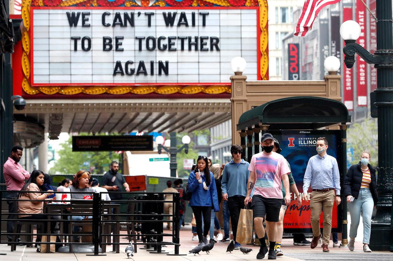 People walks near The Chicago Theatre in Chicago's famed Loop, May 18. About 60% of the US adult population has now received at least one dose of a Covid vaccine, and the country is moving to loosen restrictions. Photo: AP