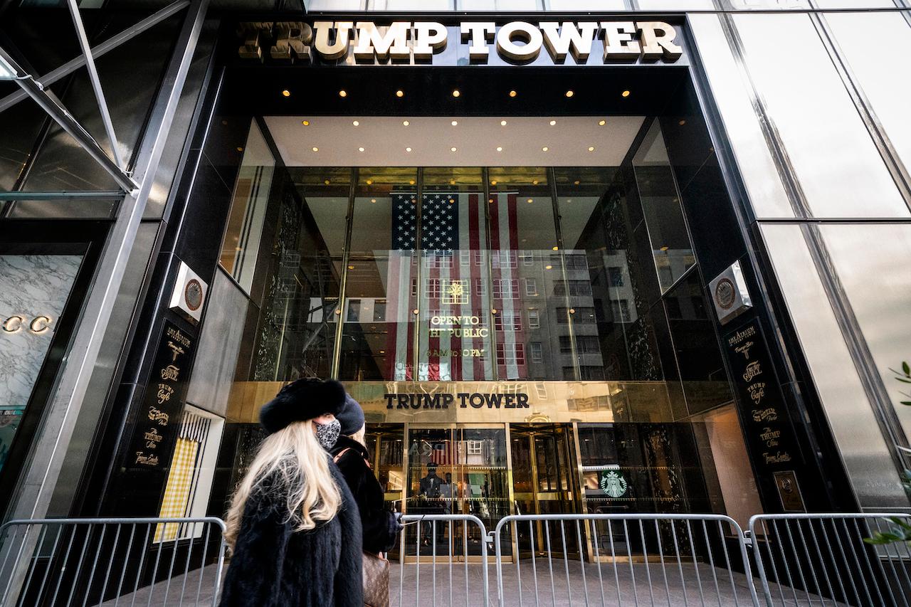 Pedestrians pass security barricades in front of Trump Tower in New York, which houses the headquarters of the Trump Organization. Photo: AP