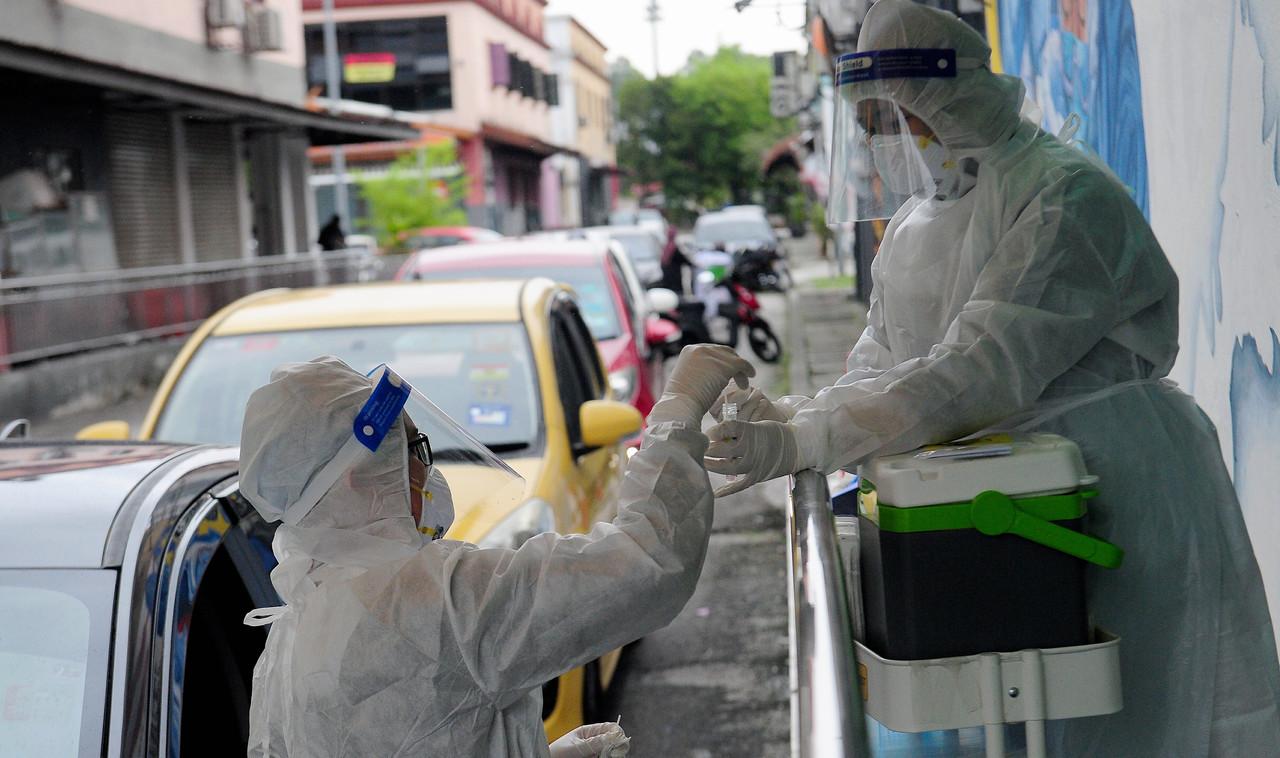 Petugas kesihatan melaksanakan ujian swab di klinik kesihatan di Shah Alam, Selangor. Gambar: Bernama