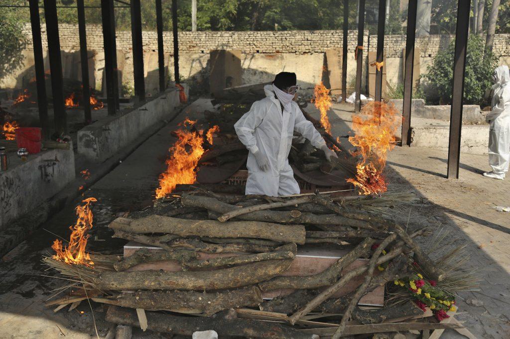 A family member performs the last rites of a Covid-19 victim at a crematorium in Jammu, India, April 30. Photo: AP