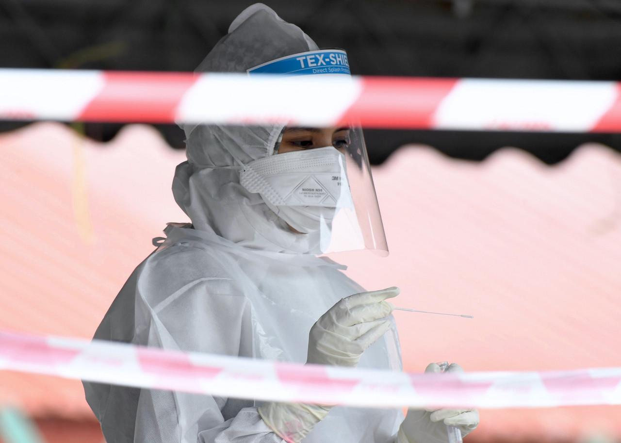 A health worker takes a swab sample to be tested for Covid-19 at a clinic screening in Alor Setar. Photo: Bernama