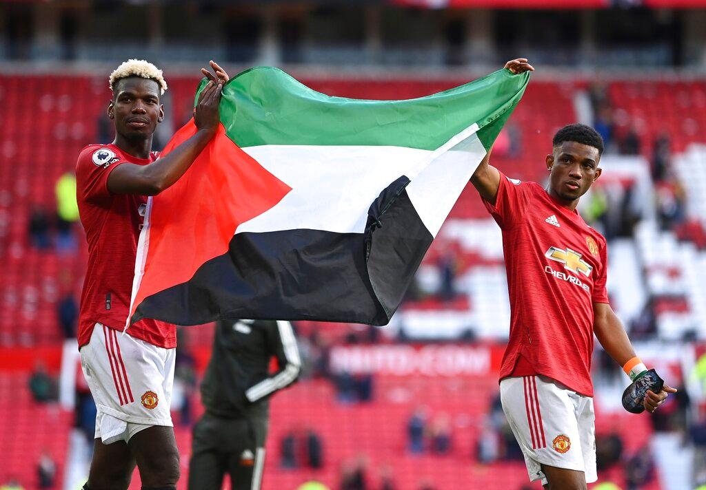 Pemain Manchester United Paul Pogba dan Amad Diallo mengibarkan bendera Palestin selepas perlawanan menentang Fulham di Old Trafford. Gambar: AP