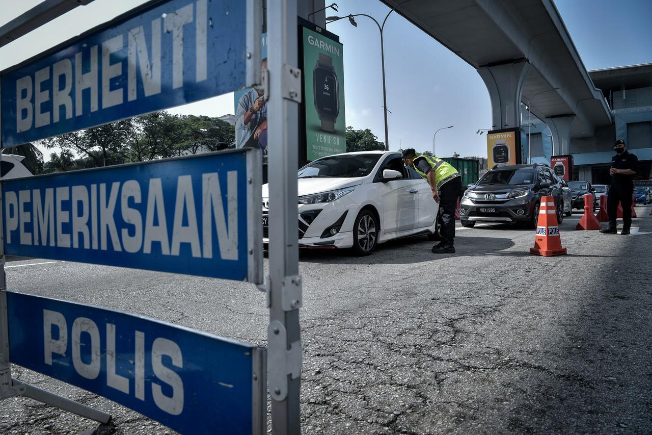 Police officers man a roadblock in Jalan Cheras, Kuala Lumpur, under the movement control order enforced across most of the country. Photo: Bernama