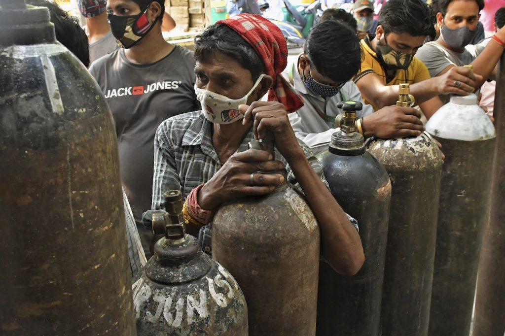 Indians wait to refill oxygen cylinders for Covid-19 patients at a gas supplier facility in New Delhi, India, May 8. Scammers are taking every advantage they can of the desperate situation in India, where resources like oxygen are few and far in between. Photo: AP