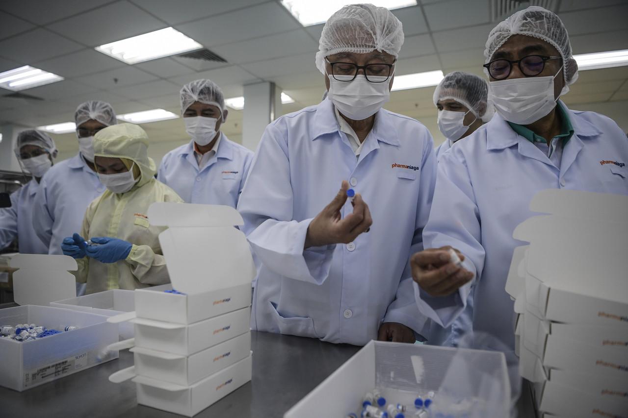 Senior Minister for Security Ismail Sabri Yaakob (second right) watches the bottling process for Sinovac Covid-19 vaccine during a visit to the bottling factory at Pharmaniaga Lifescience factory in Puchong today. Photo: Bernama