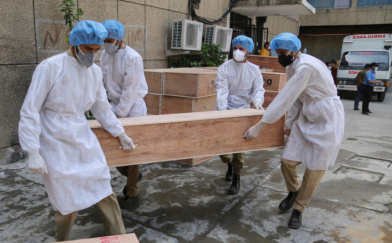 Jammu and Kashmir State Disaster Response Force soldiers carry empty coffins for transporting bodies of people who died of Covid-19 outside government medical hospital in Jammu, India, May 19. Photo: AP