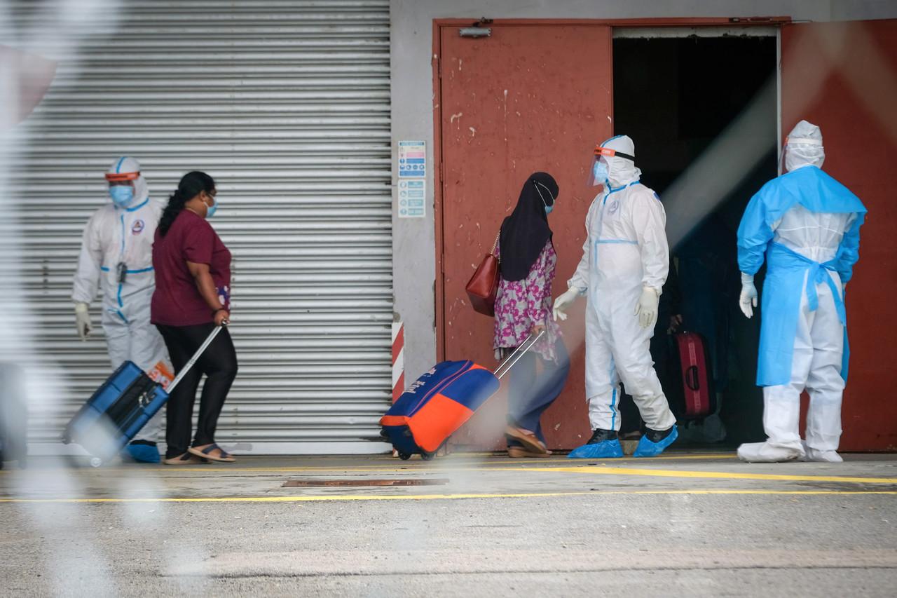 Health workers escort Covid-19 patients into the low-risk quarantine and treatment centre at the Melaka International Trade Centre in Ayer Keroh. Photo: Bernama