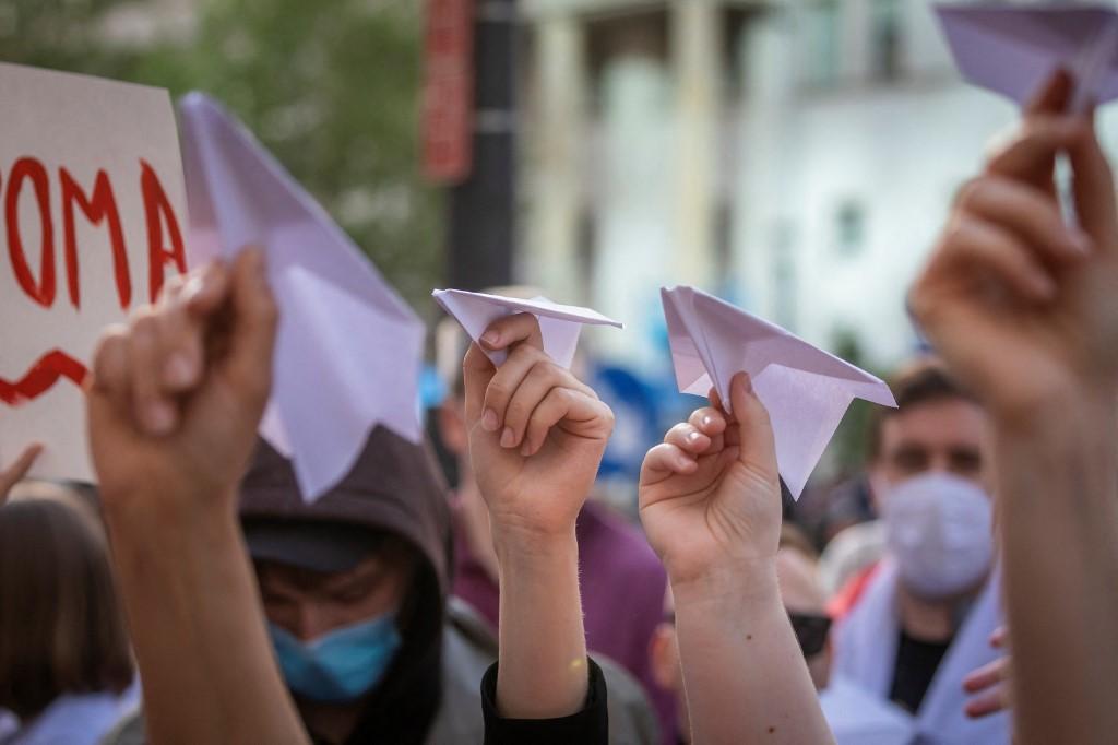 Belarusians living in Poland and Poles supporting them hold up paper planes during a demonstration in front of the European Commission office in Warsaw on May 24, demanding freedom for Belarus opposition activist Roman Protasevich a day after a Ryanair flight from Athens to Vilnius carrying the dissident journalist was diverted while in Belarusian airspace. Photo: AFP