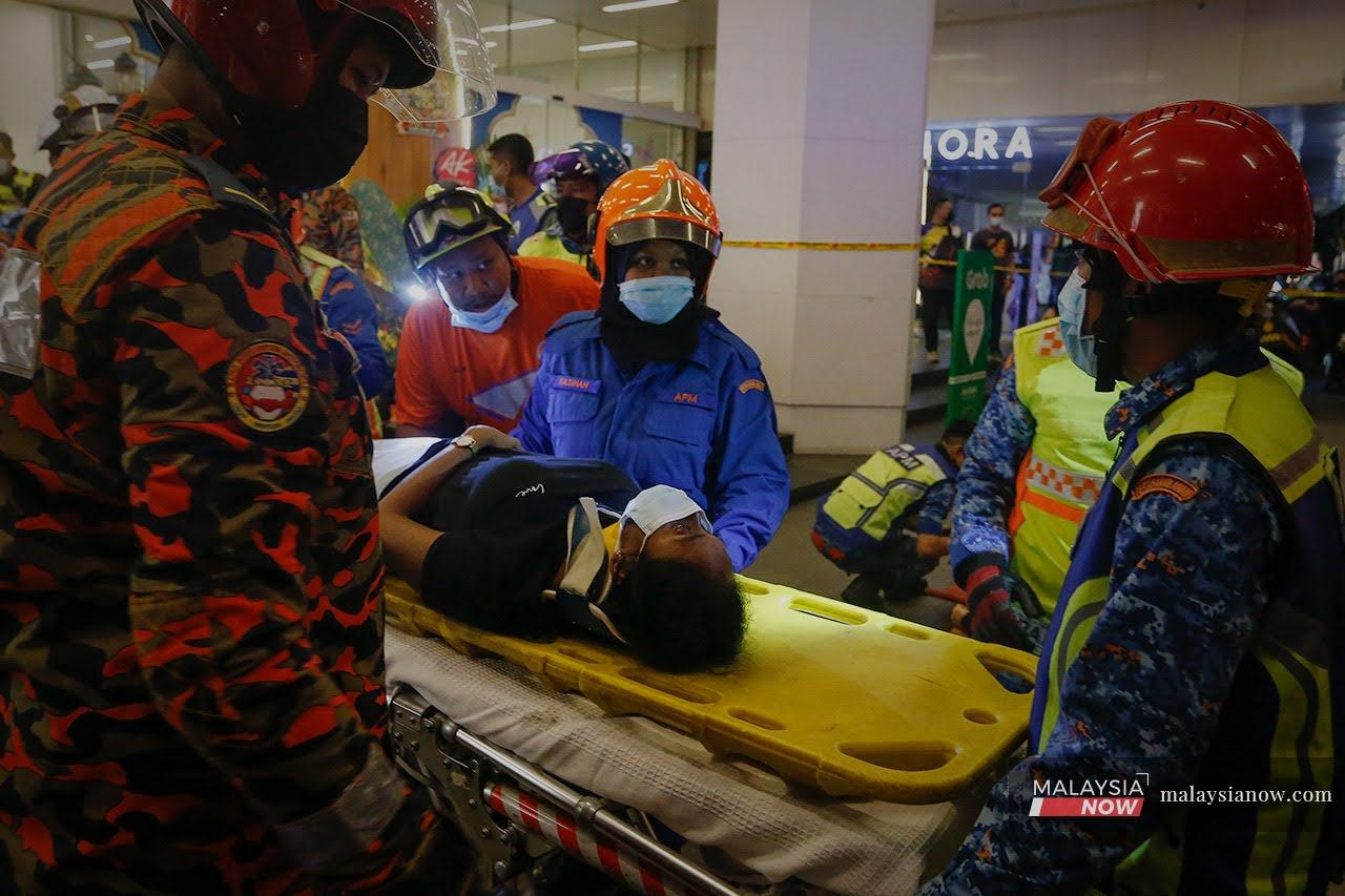 A passenger is carried out on a stretcher from one of two LRT trains which collided near the KLCC station in Kuala Lumpur last night.