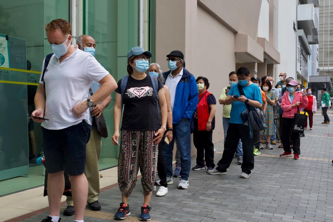 People queue up outside a vaccination centre for Pfizer-BioNTech in Hong Kong, April 6. A total of 3,263,000 doses of the Pfizer-BioNTech vaccines have been shipped to Hong Kong so far but only 1,231,600 have been administered. Photo: AP