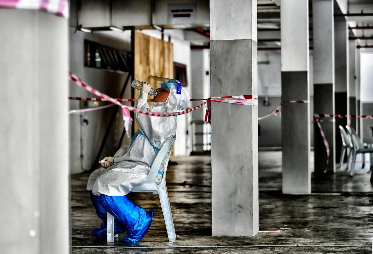 A health worker takes a break from screening members of the public for Covid-19 at a drive-thru test centre in Kuching, Sarawak. Photo: Bernama