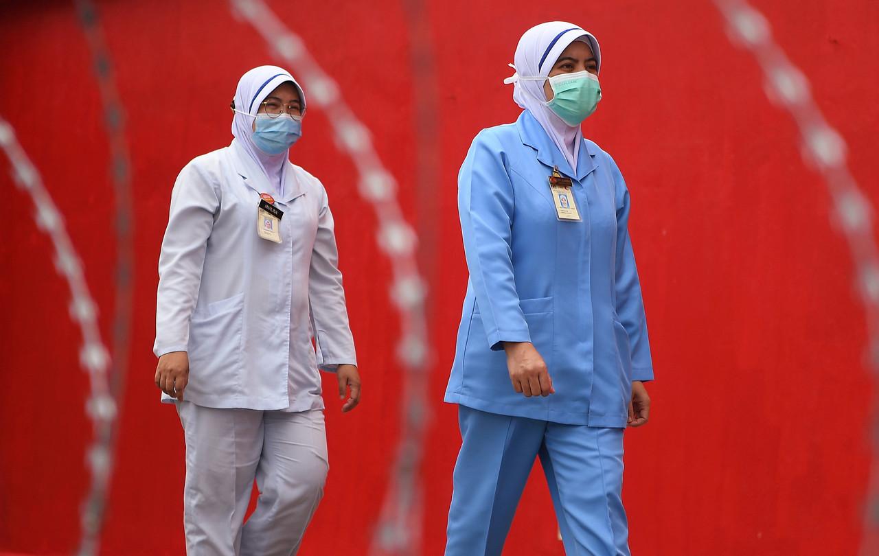 Frontliners walk past the Covid-19 low-risk quarantine and treatment centre at Universiti Malaysia Pahang in Kuantan today. Photo: Bernama