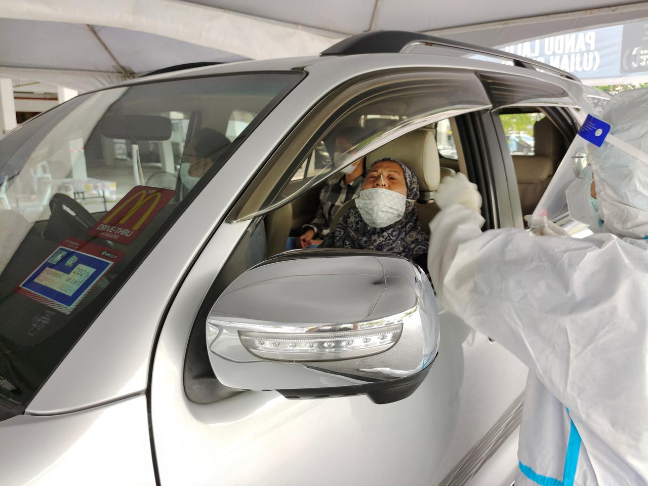 A health worker takes a swab sample to be tested for Covid-19 at a one-stop screening centre in Kuching, Sarawak. Photo: Bernama