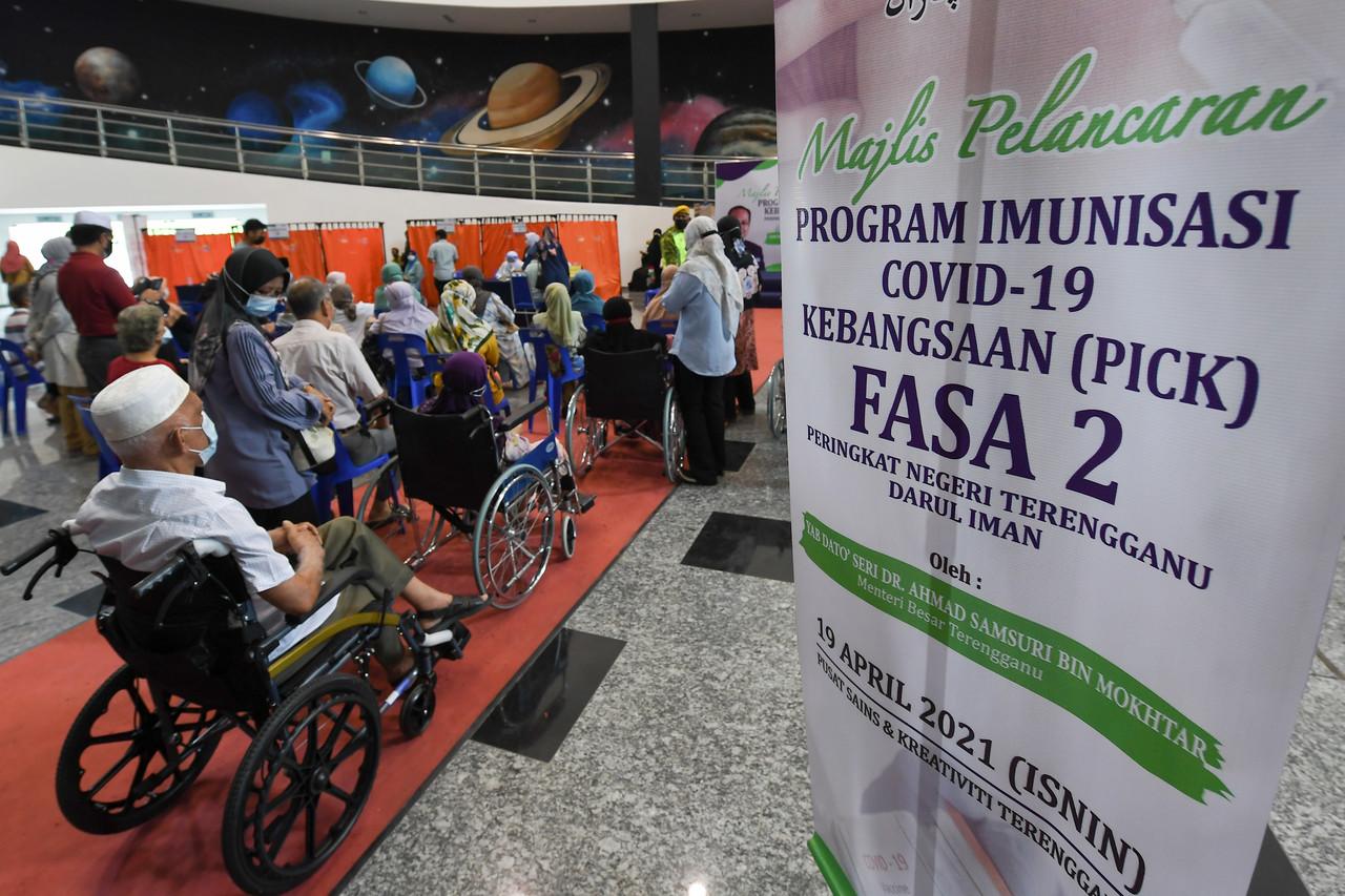 Senior citizens and those in the high-risk group wait for their turn to be vaccinated against Covid-19 under the national immunisation programme at the Terengganu Science and Creativity Centre in Kampung Laut. Photo: Bernama