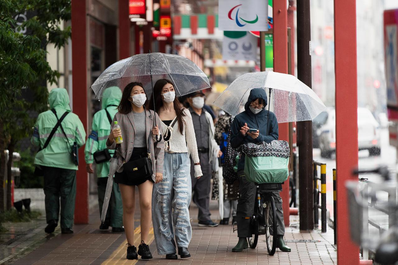 People wearing face masks to help curb the spread of the coronavirus walk around in the famed Asakusa shopping area on a rainy day in Tokyo, May 27. Photo: AP