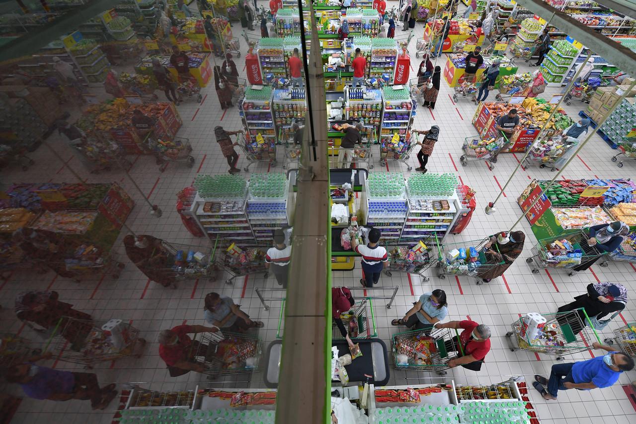 Shoppers at a grocery mart in Terengganu queue to pay for their purchases ahead of the enhanced movement control order covering 21 areas in Kuala Terengganu. Photo: Bernama