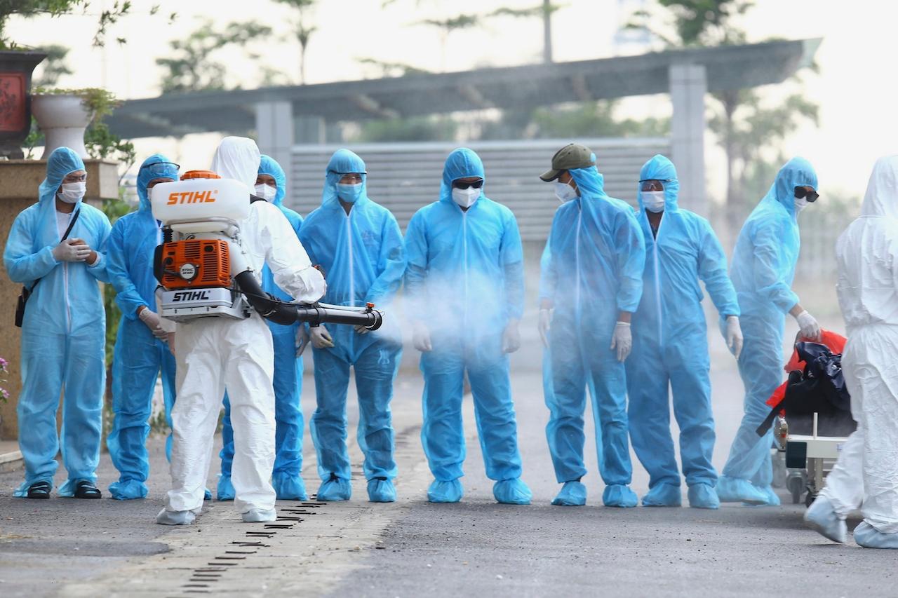 A health worker disinfects arriving Vietnamese Covid-19 patients at the National Hospital of Tropical Diseases in Hanoi, Vietnam, in this July 29, 2020 file photo. Photo: AP