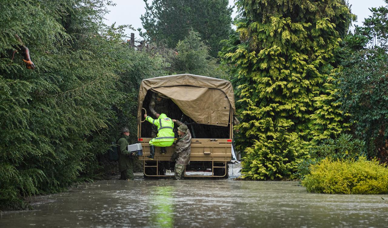 New Zealand Defense Force personnel assist a family with their evacuation near Ashburton in New Zealand's South Island, May 30. Photo: AP