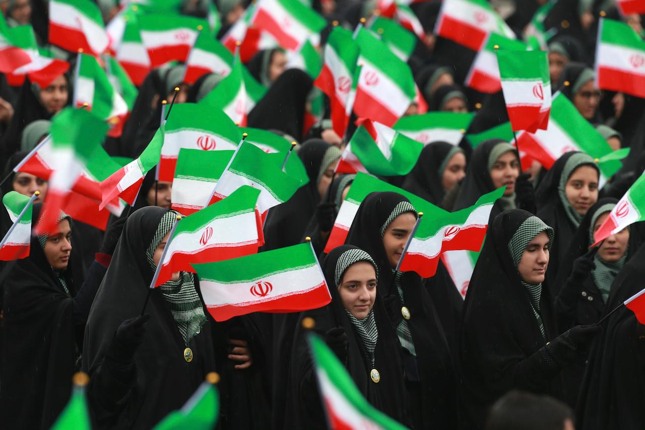 Iranians wave national flags during a ceremony celebrating the 40th anniversary of the Islamic Revolution, at the Azadi, or Freedom, Square, in Tehran, Iran, in this Feb 11, 2019 file photo. Photo: AP
