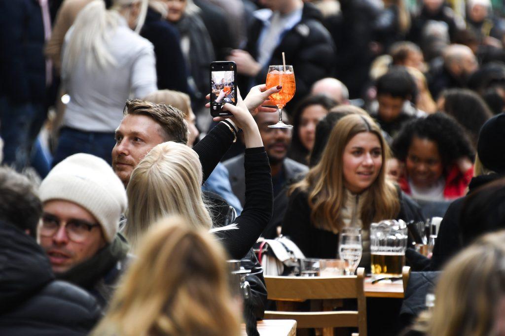 A woman takes a picture of her drink in Soho, London, on the day some of England's coronavirus lockdown restrictions were eased by the government, April 12. Photo: AP