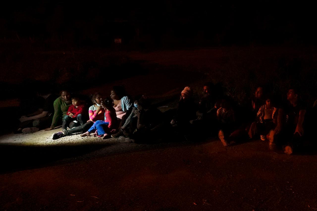 Migrants mainly from Honduras and Nicaragua sit in line after turning themselves in upon crossing the US-Mexico border on May 17, in La Joya, Texas. Photo: AP