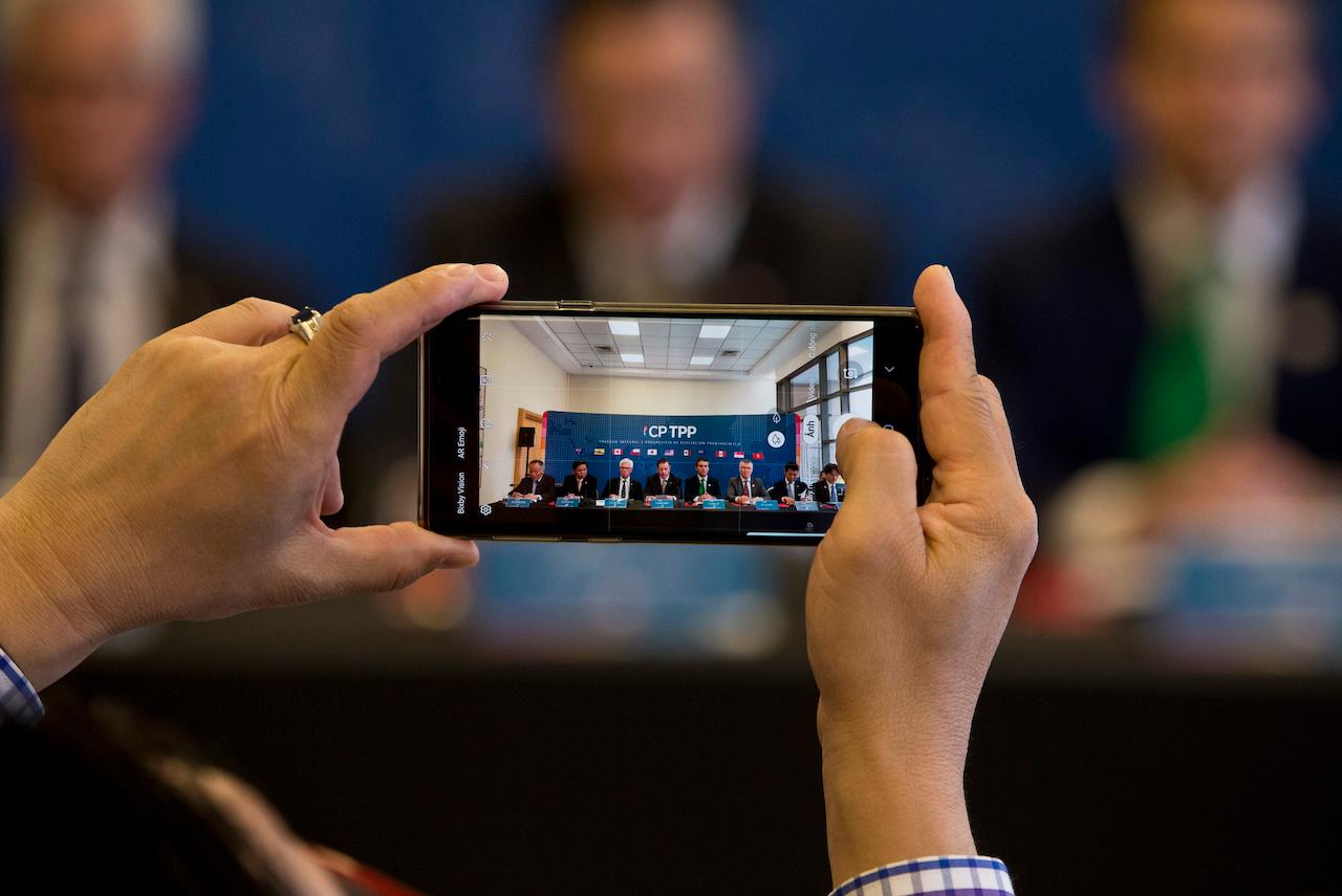A man takes a photo with his mobile phone during a meeting of the Comprehensive and Progressive Agreement for Trans-Pacific Partnership in Santiago, Chile, May 16, 2019. Photo: AP