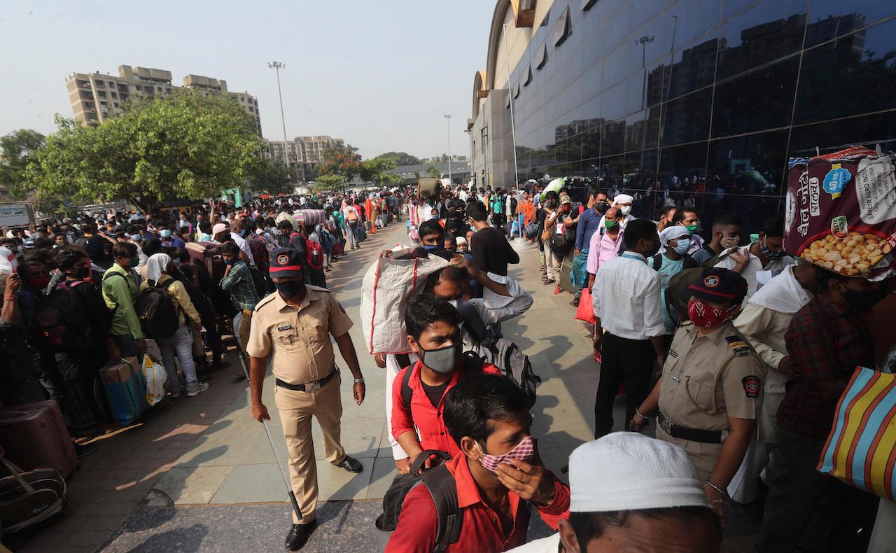 People wearing masks as a precaution against the coronavirus stand in queues to board trains at Lokmanya Tilak Terminus in Mumbai, India, April 14. Photo: AP