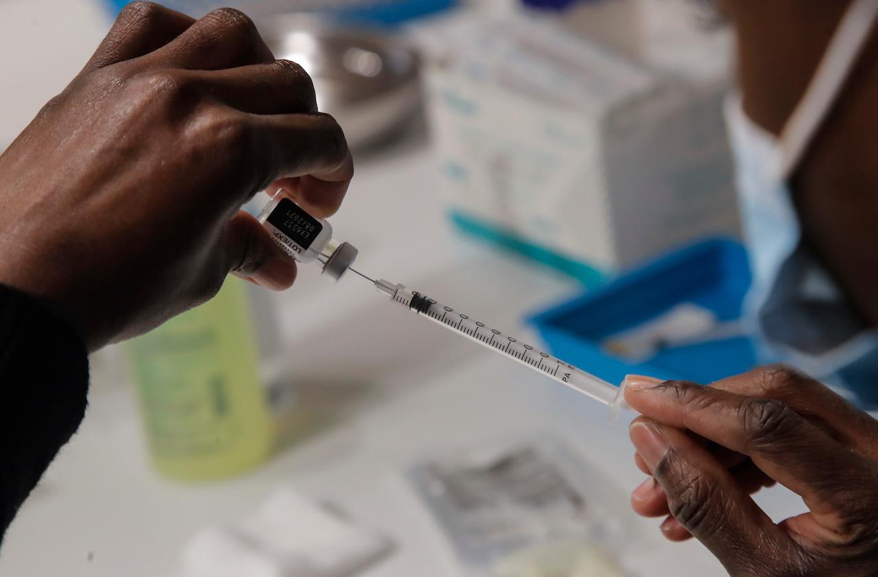A member of the Paris' fire brigade prepares a syringes with the Pfizer Covid-19 vaccine at a vaccination centre in Paris, May 6. Photo: AP