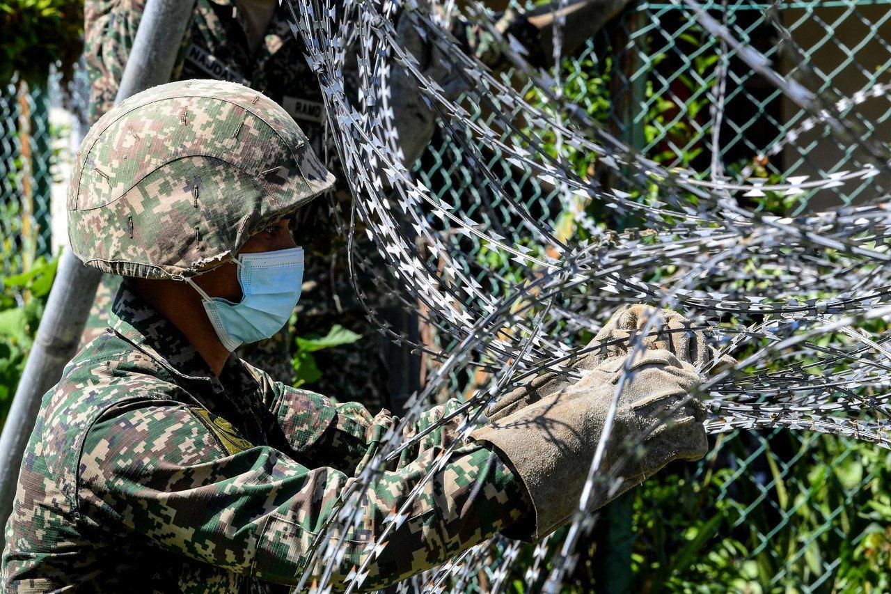 Army personnel put up a barbed wire fence around the Taman Utama area in Sandakan which has been placed under enhanced movement control order until June 17. Photo: Bernama