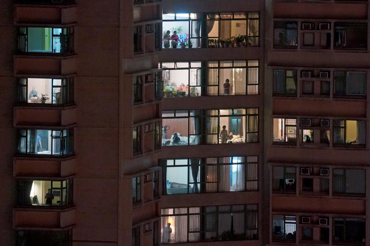 Residents seen in their homes in an apartment block in a residential area of Hong Kong. Photo: AP
