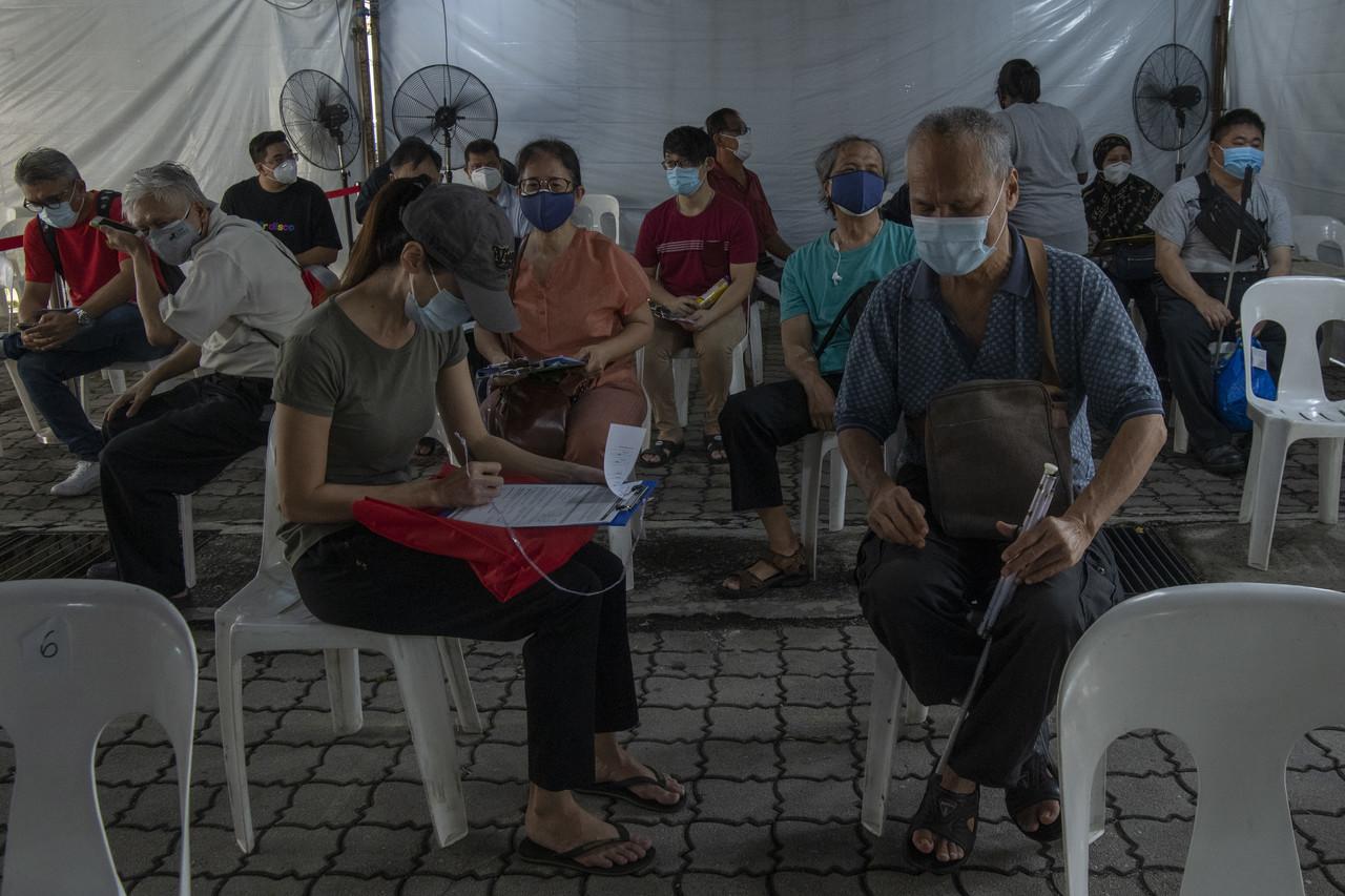 Visually impaired people together with their guardians fill out registration forms for vaccination against Covid-19 at the Malaysian Association for the Blind in Kuala Lumpur today. Photo: Bernama