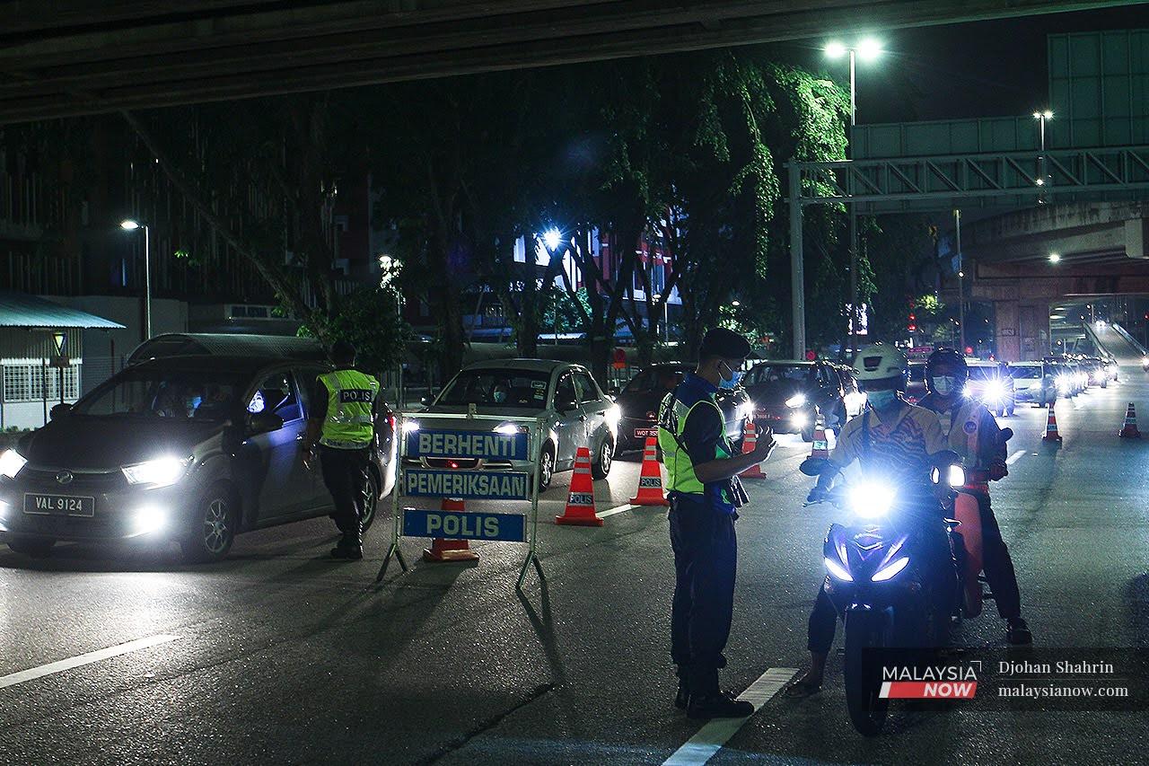 Anggota polis membuat pemeriksaan rentas daerah di sekatan jalanraya berikutan pelaksanaan PKP di Selangor, Kuala Lumpur dan Putrajaya.
