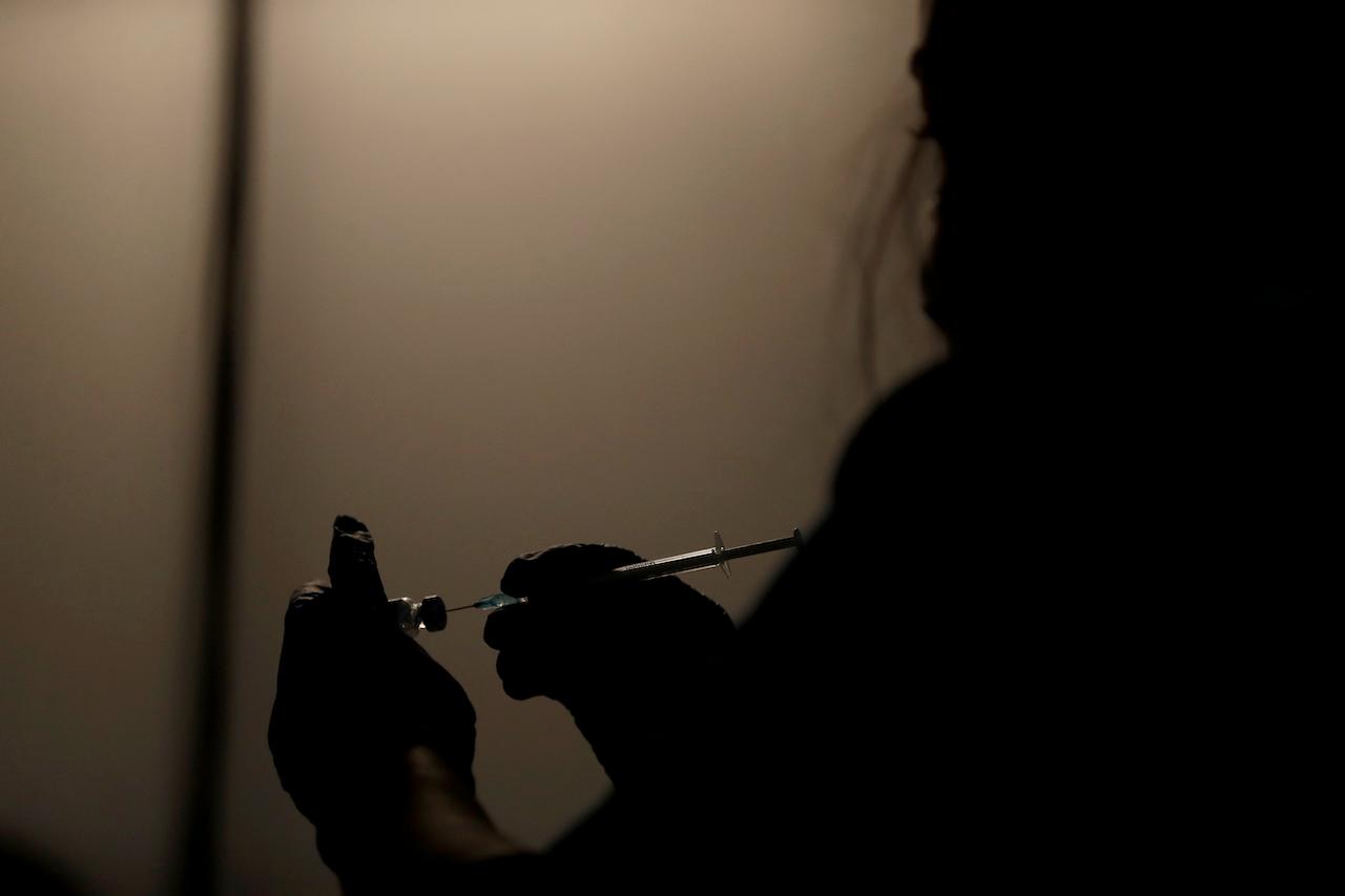 A volunteer prepares to administer a dose of the Pfizer vaccine at a vaccination centre in Neasden, north London, May 1. Photo: AP