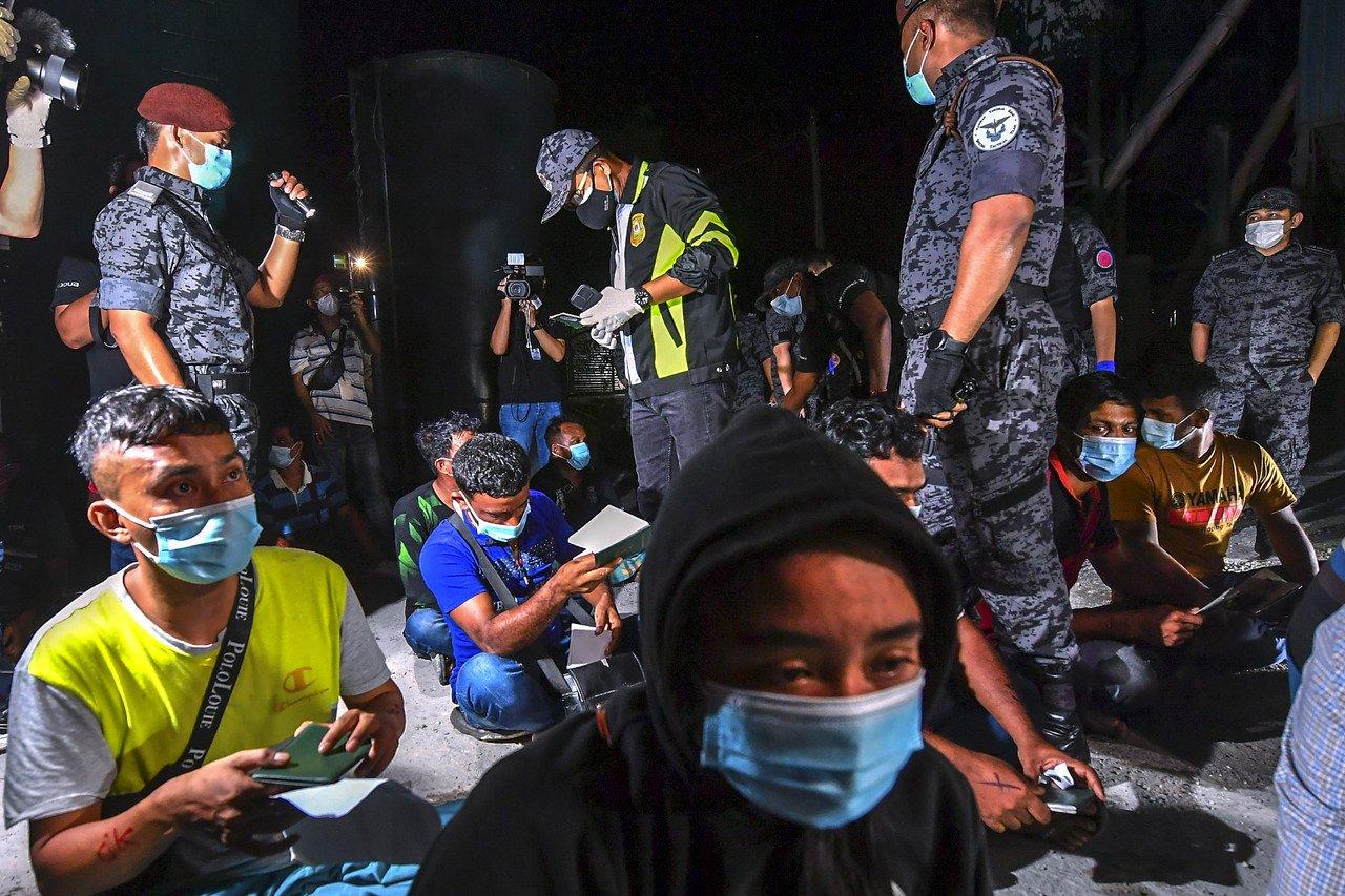 Immigration director-general Khairul Dzaimee Daud checks the documents of a migrant worker during a raid in Cyberjaya last night. Photo: Bernama