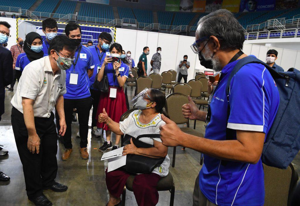 Ketua Menteri Pulau Pinang Chow Kon Yeow berbual dengan penerima vaksin di PPV Setia Spice Arena di Bayan Lepas hari ini. Gambar: Bernama