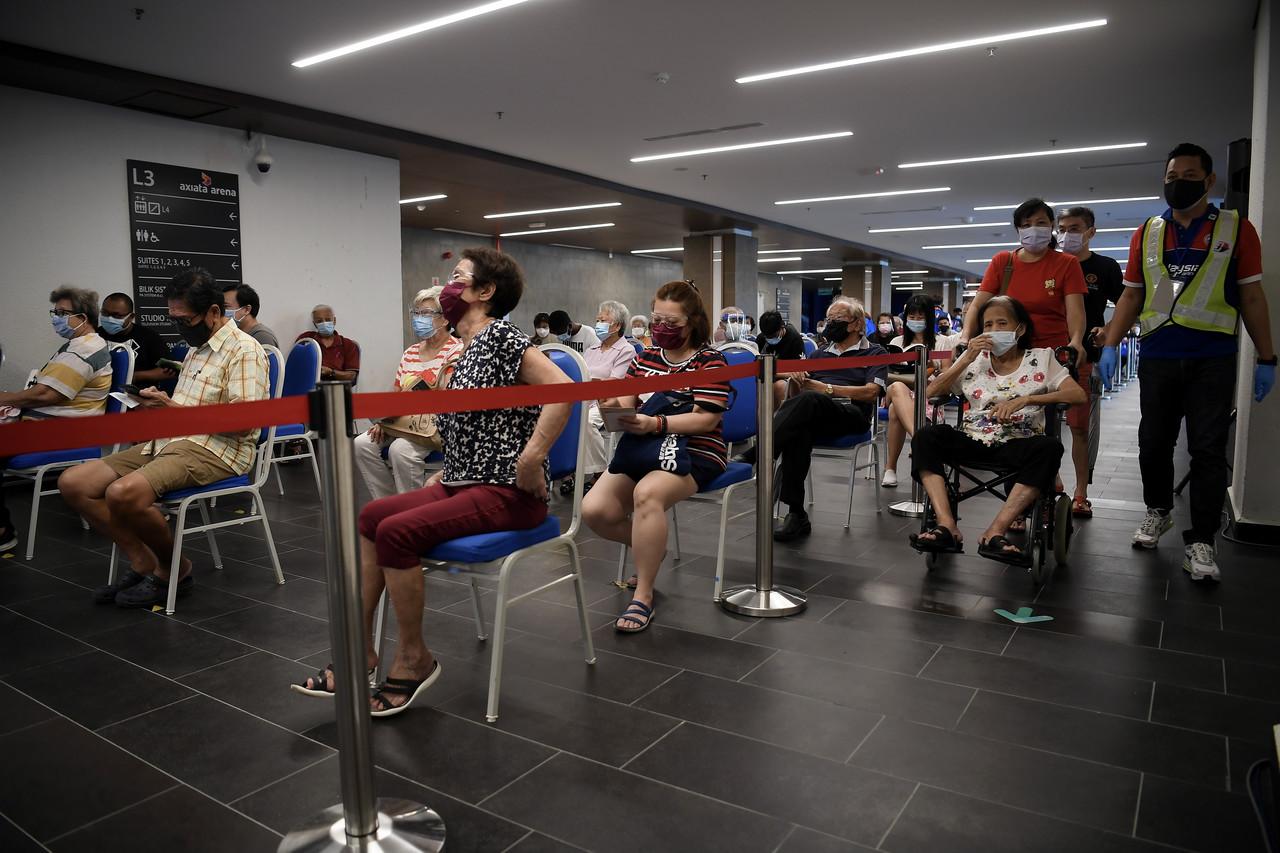 People wait in line for their turn to receive a dose of Covid-19 vaccine at the Axiata Arena vaccination centre in Bukit Jalil, Kuala Lumpur. Photo: Bernama