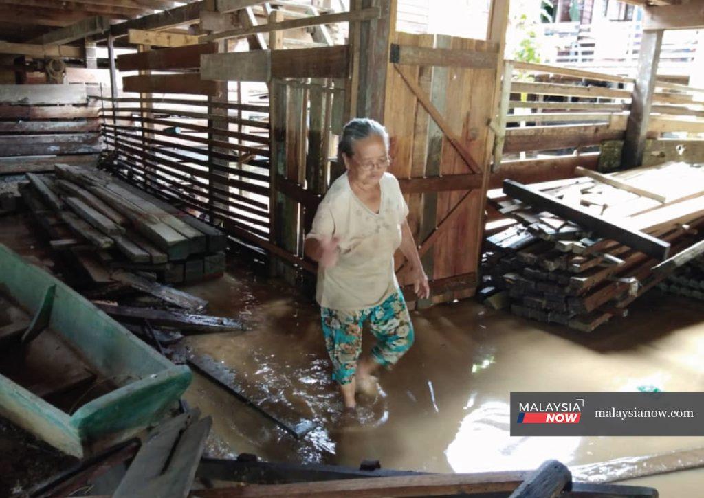 Seorang wanita memeriksa apa yang dapat diselamatkan selepas banjir surut di rumah panjang Lio Mato di Ulu Baram, Sarawak.