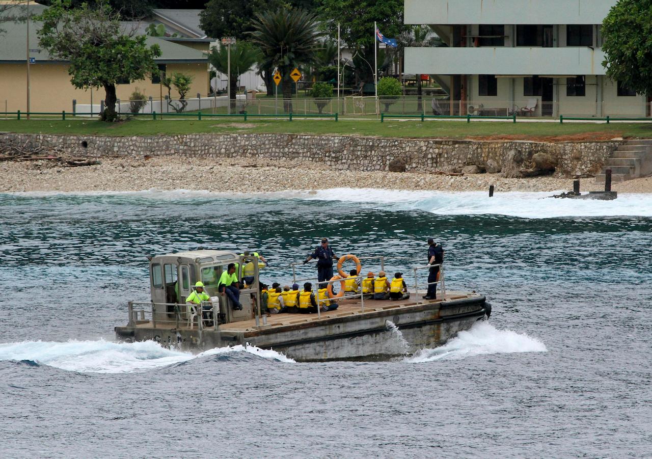 A group of asylum seekers are taken by barge to a jetty on Australia's Christmas Island in this April 14, 2013 file photo. Thousands of asylum seekers have been held in facilities off the mainland since 2013, when the government introduced 'offshore processing' of those who arrive by boat. Photo: AP