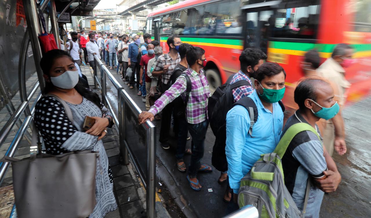 People wearing face masks as a precaution against the coronavirus stand in a queue as they wait at a bus stop in Mumbai, India, June 7. Photo: AP